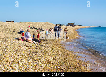 17 September 2019 Relaxing on the beach in late summer sun on the Hampshire coast pebble beach Stock Photo