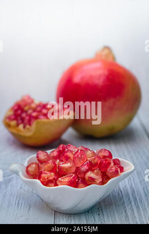 Pomegranate fresh fruit on wood white background, Pomegranates (Punica granatum) is a fruit-bearing deciduous shrub. Stock Photo
