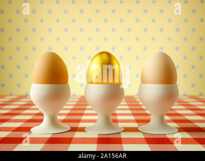 Row of eggs in egg cups with one golden egg Stock Photo