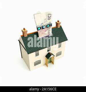 Money box house with UK GBP sterling 20 pound note paper currency Stock Photo