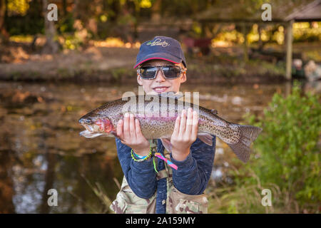 Ten year old boy with his freshly caught rainbow trout fish (4 1/2lbs) Avington Trout Fishery, Winchester, Hampshire, England, United Kingdom. Stock Photo