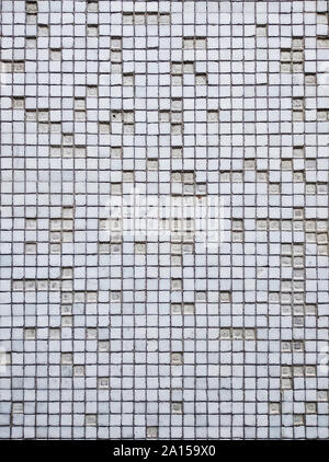 Small white damaged tiles on the wall Stock Photo