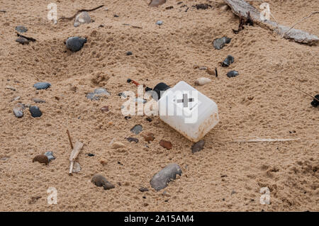 A plastic bootle with a hazard label found washed up on a Suffolk beach Stock Photo