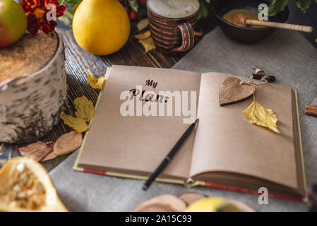 Autumn set of yellow leaves and flowers. Notebook with open pages on the table. Space for text. Top view. Concept my plan Stock Photo