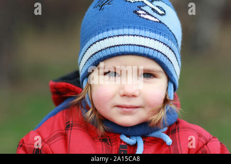 Portrait of a cute one year old girl having a stroll in the park at daytime, blurred background Stock Photo
