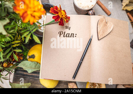 Autumn set of yellow leaves and flowers. Notebook with open pages on the table. Space for text. Top view. Concept my plan Stock Photo
