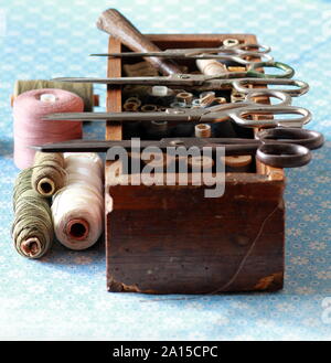 Sewing box with many thread spools and vintage scissors. Tailor occupation concept Stock Photo
