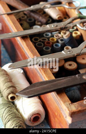 Sewing box with many thread spools and vintage scissors. Tailor occupation concept Stock Photo
