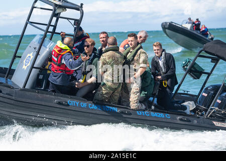 The Duke of Sussex (second left) travels on a South African Maritime Police Unit RIB during a visit to Kalk Bay Harbour, in Cape Town, on day two of the Royal couple's visit to South Africa. Stock Photo