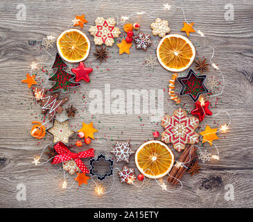 Christmas homemade gingerbread cookies, cookie cutters, spices and other ingredients stacked in a circle on a wooden table. Christmas Festive backgrou Stock Photo