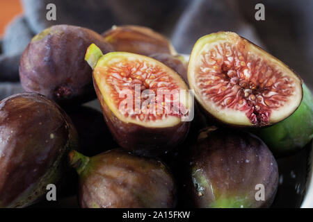 Whole figs and one fig sliced in half, close up Stock Photo