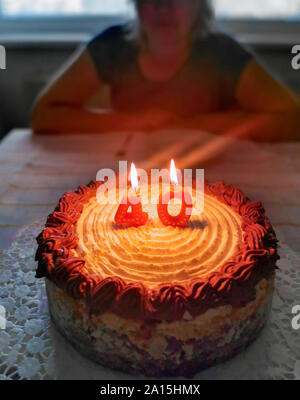 Cake for 40th birthday with candles with blonde woman in background Stock Photo