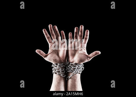 Two hands in chains isolated on black background with clipping path Stock Photo