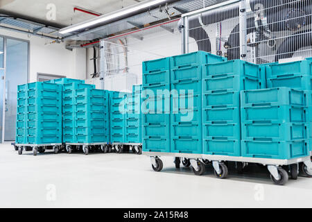 Turquoise colored containers inside modern factory warehouse, Stuttgart, Germany