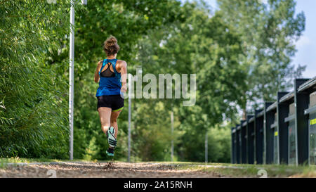 Young woman jogging on a woodchip trail Stock Photo