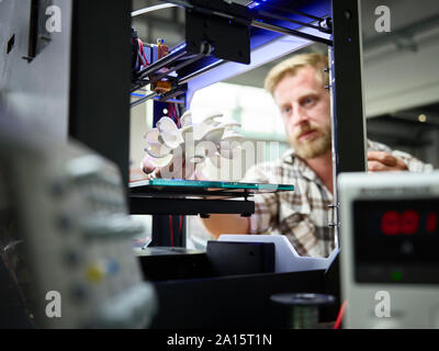 Technician with turbine wheel being printed in 3d printer Stock Photo