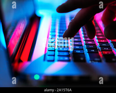Man typing at his laptop computer at night Stock Photo