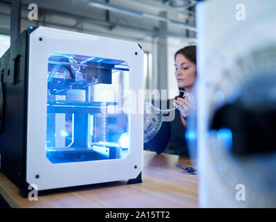 Woman and 3D printer on table Stock Photo
