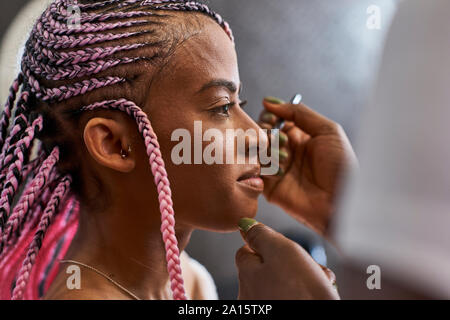 Visagiste applying makeup on young woman's face Stock Photo