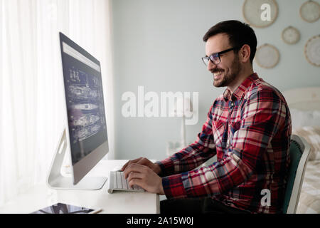 Young handsome designer working on project on computer Stock Photo