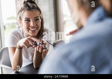 Happy young woman and man working on computer equipment in office Stock Photo