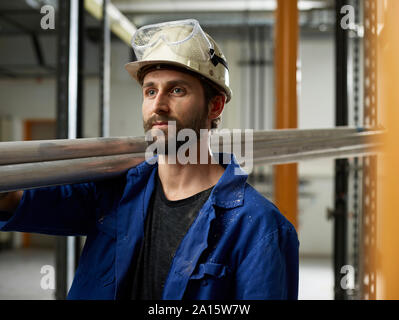 Portrait of worker carrying aluminium tubes Stock Photo