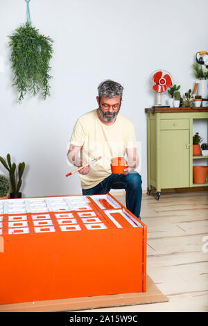 Man painting furniture with brush at home Stock Photo