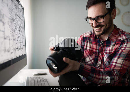 Young handsome designer working on project on computer Stock Photo