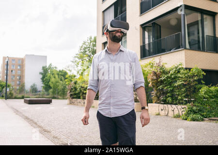 Man wearing Virtual Reality Glasses outdoors Stock Photo