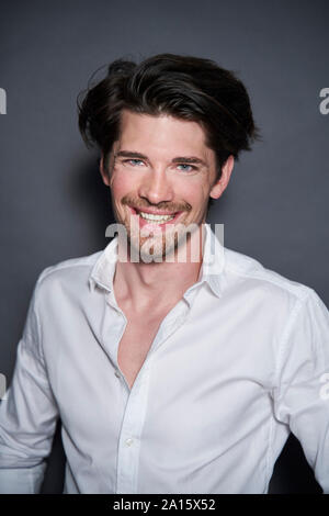 Portrait of smiling handsome man wearing white shirt Stock Photo