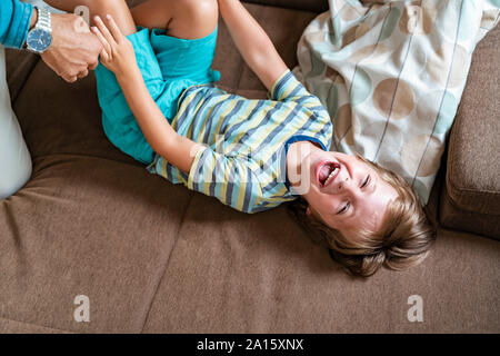 Playful father and son on couch at home Stock Photo
