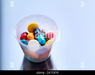 Medicine, Pills in a plastic cup Stock Photo