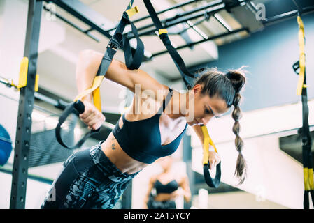 Young woman doing suspension traning in the gym Stock Photo