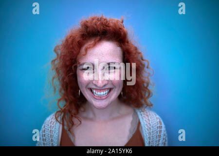 Portrait of happy young woman in blue light Stock Photo