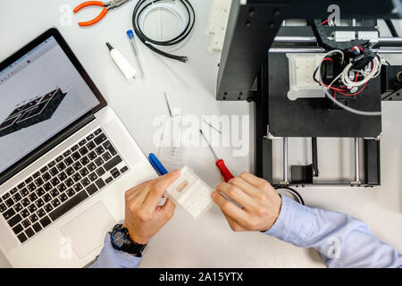 Student setting up 3D printer, overhead view Stock Photo