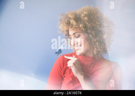 Smiling woman with flying butterfly, robot Stock Photo
