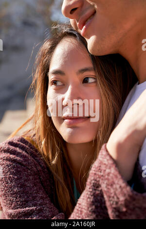 Happy young woman hugging boyfriend outdoors Stock Photo