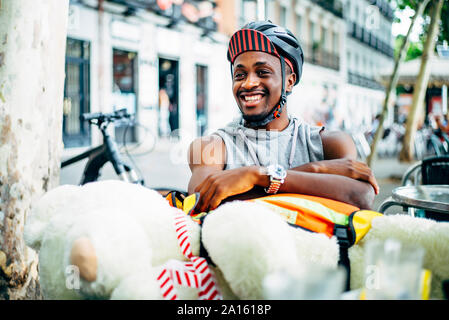 Portrait of happy bicycle courier delivering a teddy bear Stock Photo