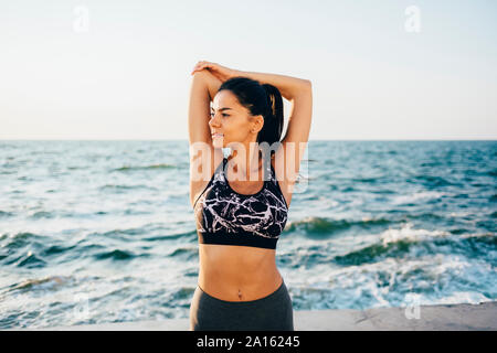 Young sportswoman stretching her arm Stock Photo