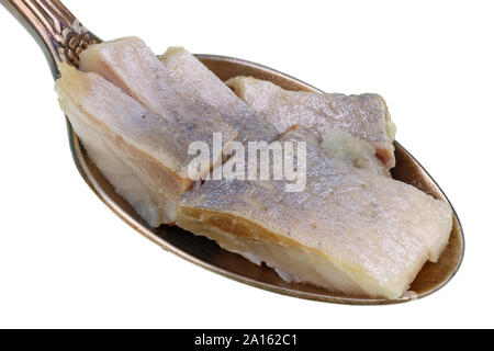 In the old golden spoon there is a small pile of food - pieces of pickled salted norwegian herring  fish. Isolated on white studio macro Stock Photo