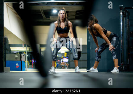 Twin sisters in gym practicing with ropes Stock Photo