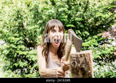 Screaming woman chopping wood Stock Photo