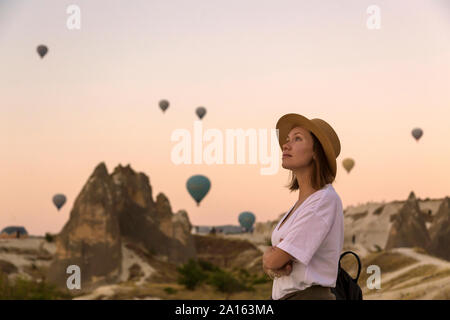 Young woman and hot air ballons, Goreme, Cappadocia, Turkey Stock Photo