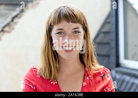 Portrait of smiling young woman with freckles and nose piercing Stock Photo