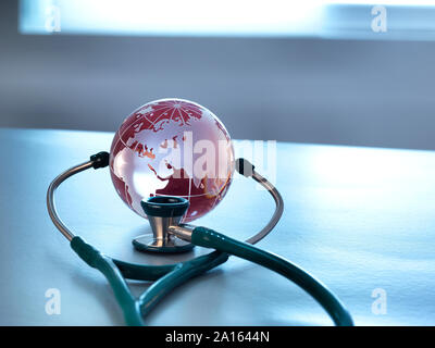 Global Healthcare, a glass globe and a stethoscope Stock Photo