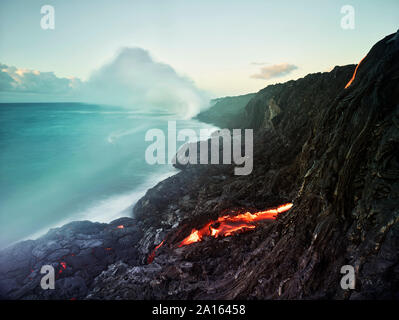 Lava flowing from Pu'u O'o' in sea at Hawaii Volcanoes National Park against sky Stock Photo