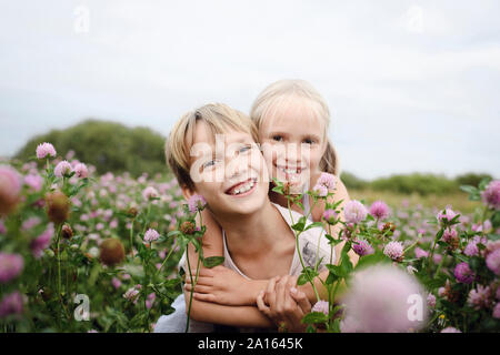 Two smiling children on clover field Stock Photo