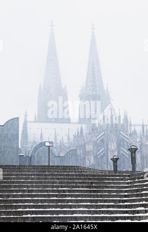 Low angle view of Cologne Cathedral and Museum Ludwig during snowfall in city against sky Stock Photo