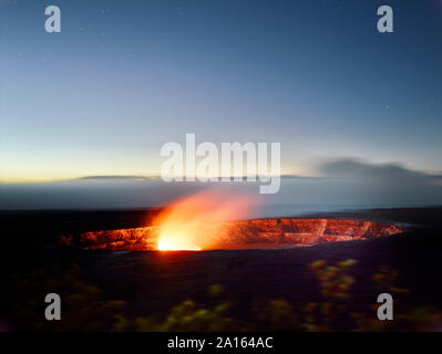 Glowing Halema'uma'u Crater in Hawaii Volcanoes National Park against sky at dusk Stock Photo