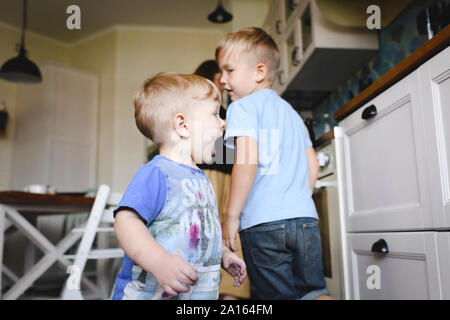 Two little boys running in the kitchen Stock Photo